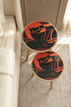 Top view of Orange Horse printed wooden nesting side tables, set of two, beside a bed in a luxury bedroom